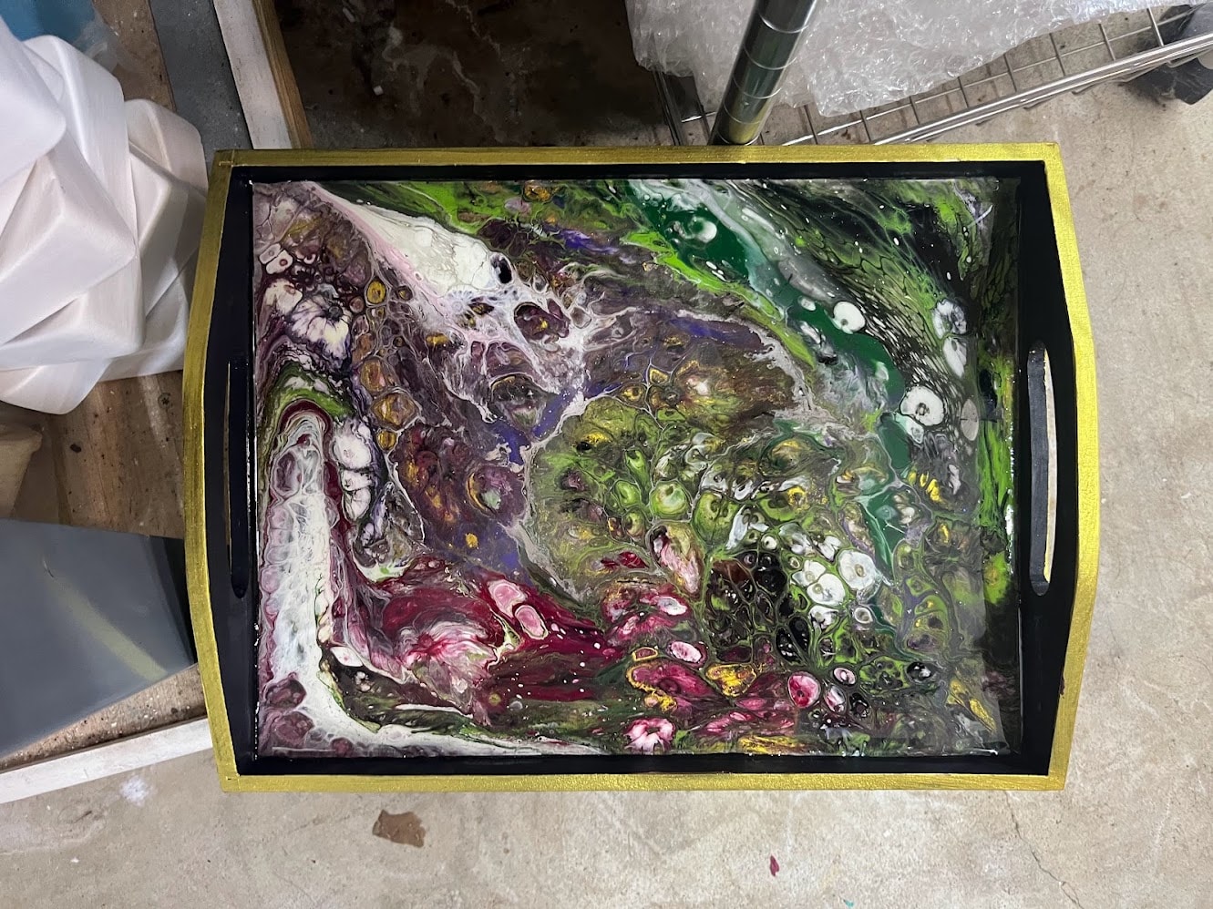 Abstract fluid pour painting on a decorative tray with gold frame