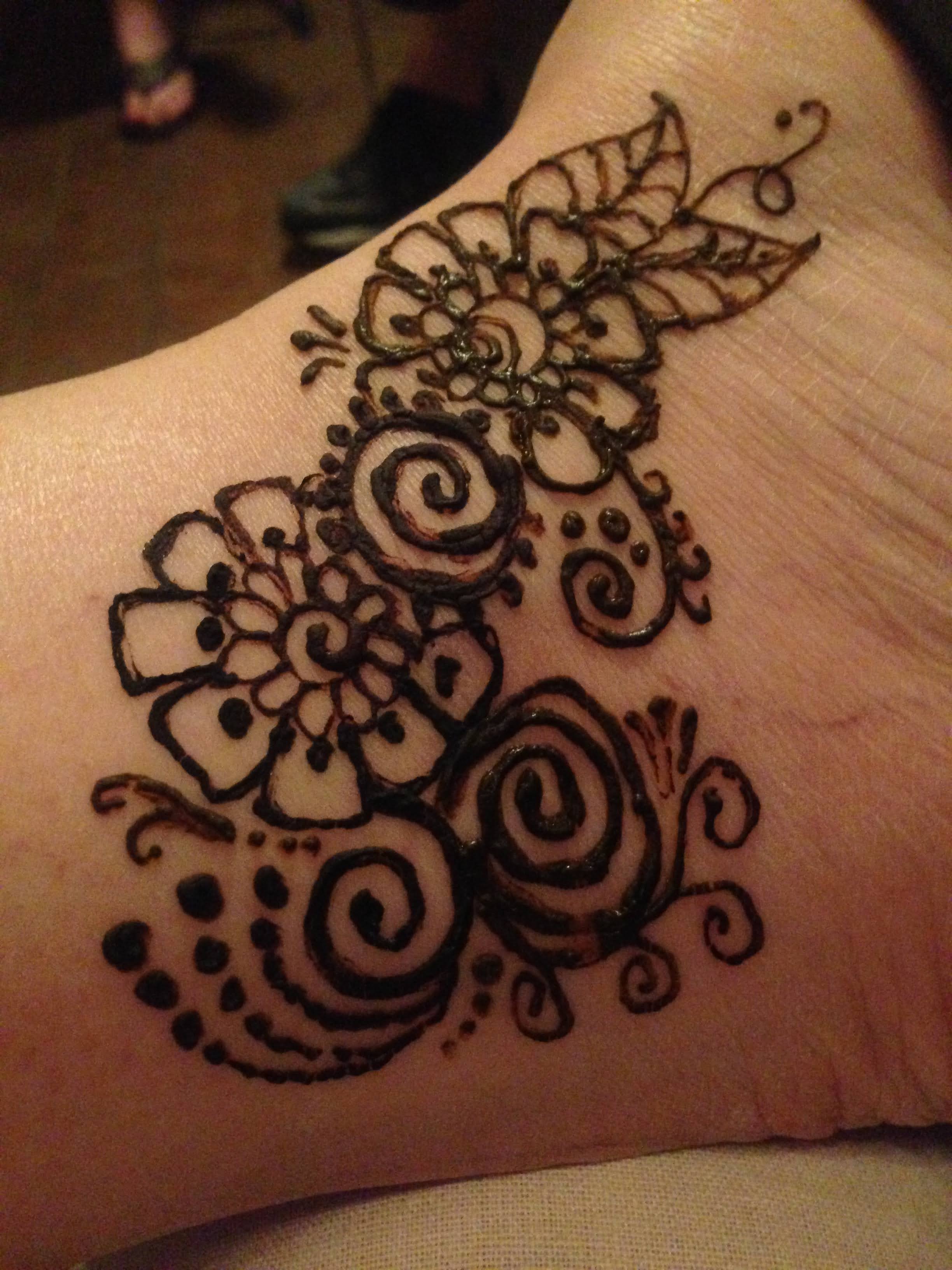 Floral and swirl henna design on wrist